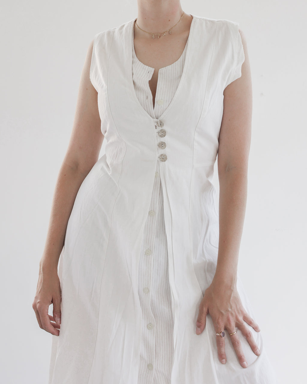 Robe blanche avec 4 boutons sur le décolleté