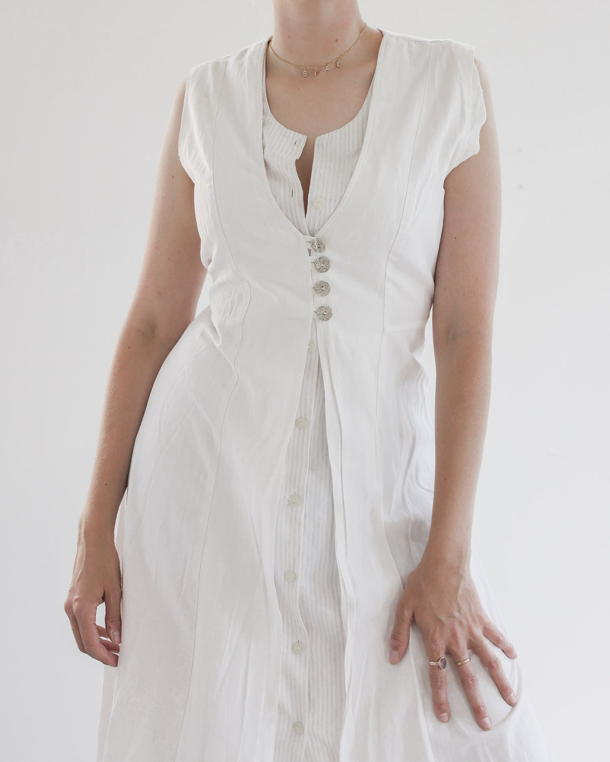 Robe blanche avec 4 boutons sur le décolleté