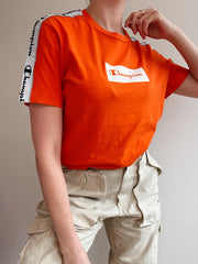 Im Shop erhältlich: Champion S orangefarbenes T-Shirt