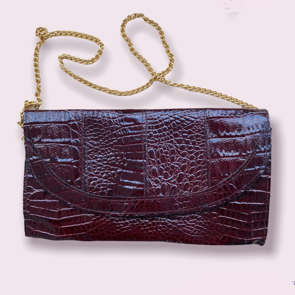 Burgunderrote Clutch mit goldenem Riemen